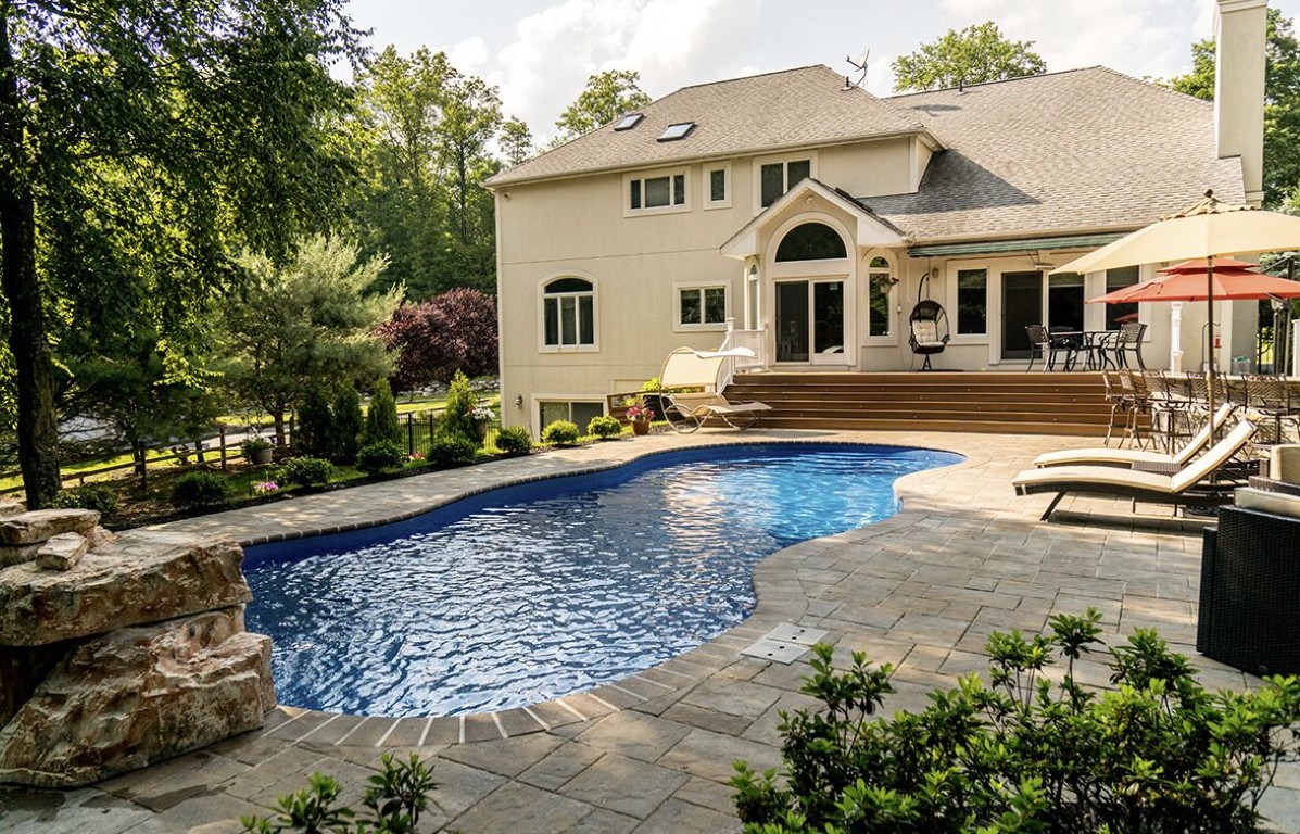 Beautiful backyard pool with professional landscaping and clear water