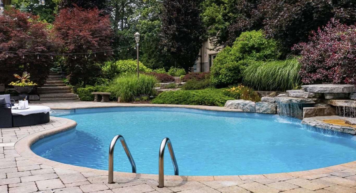 Luxury pool with waterfall feature and professional landscaping