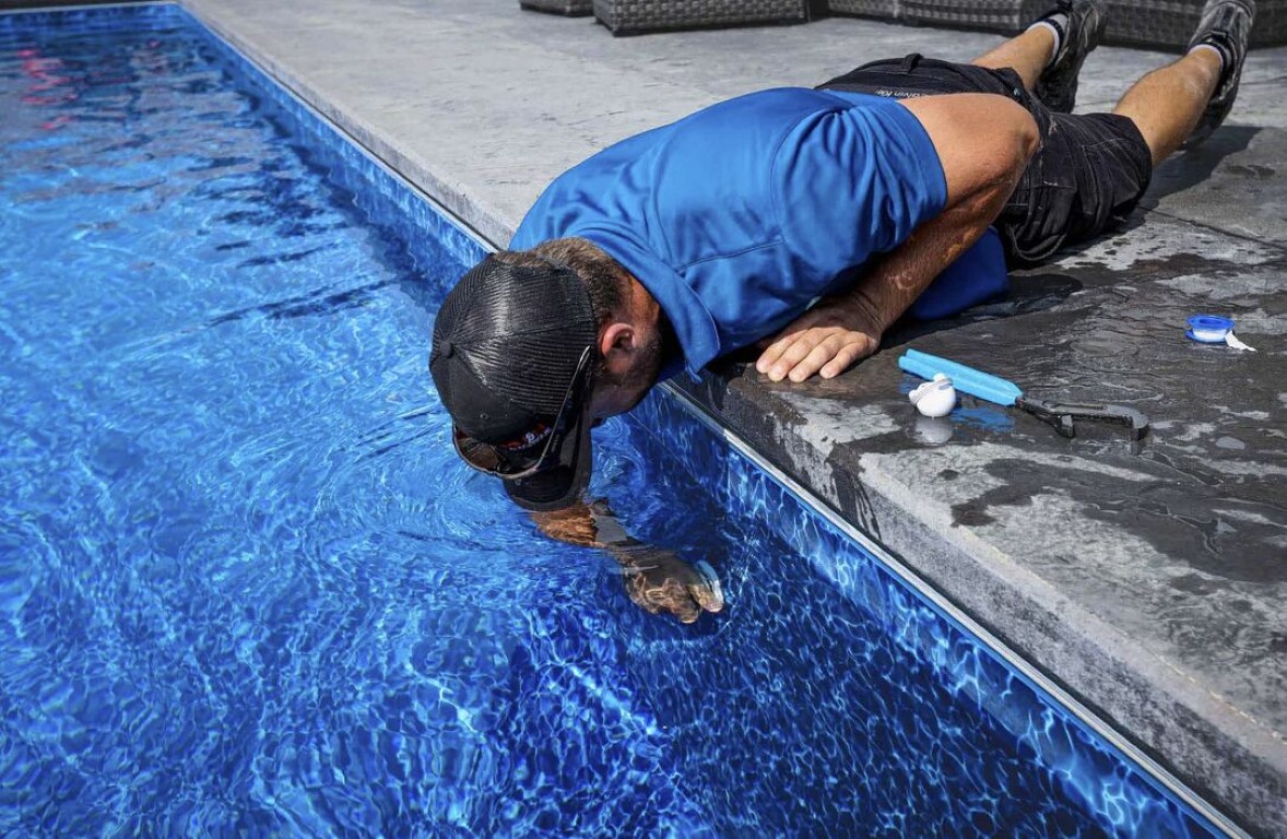 Pool technician restoring green pool to clear water
